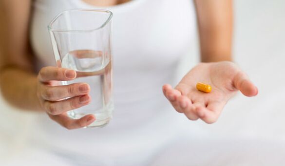 mengambil tablet untuk mencegah cacing